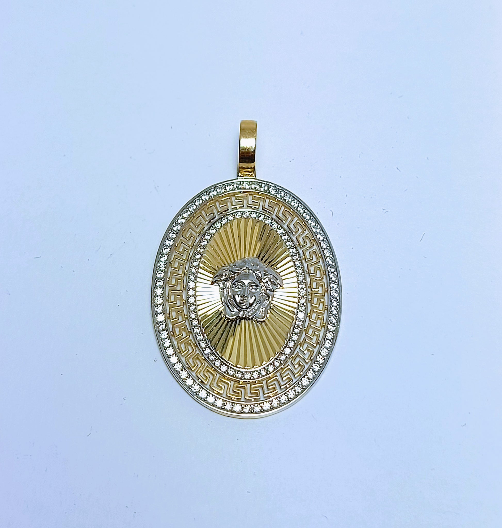 Oval shaped reflecting Versace head gold pendant